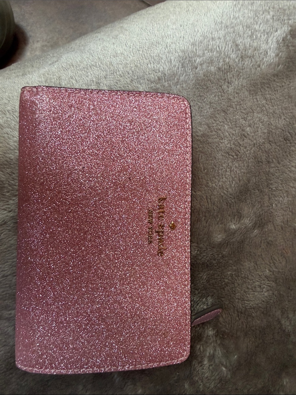 kate spade glitter zip-around wallet in pink with gold logo